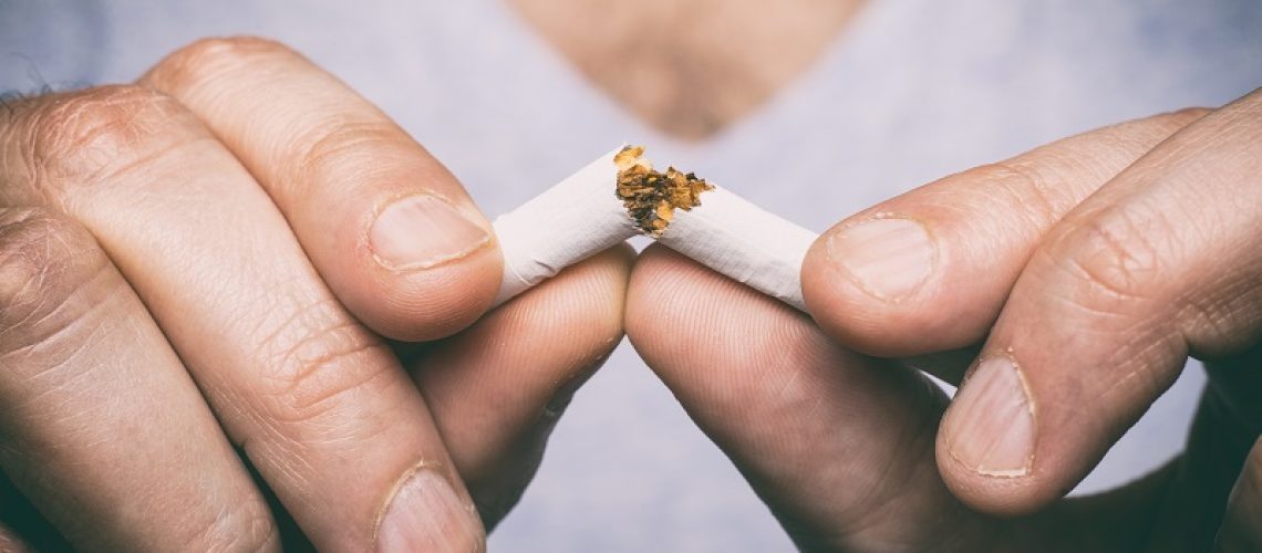 Quitting smoking - male hand crushing cigarette