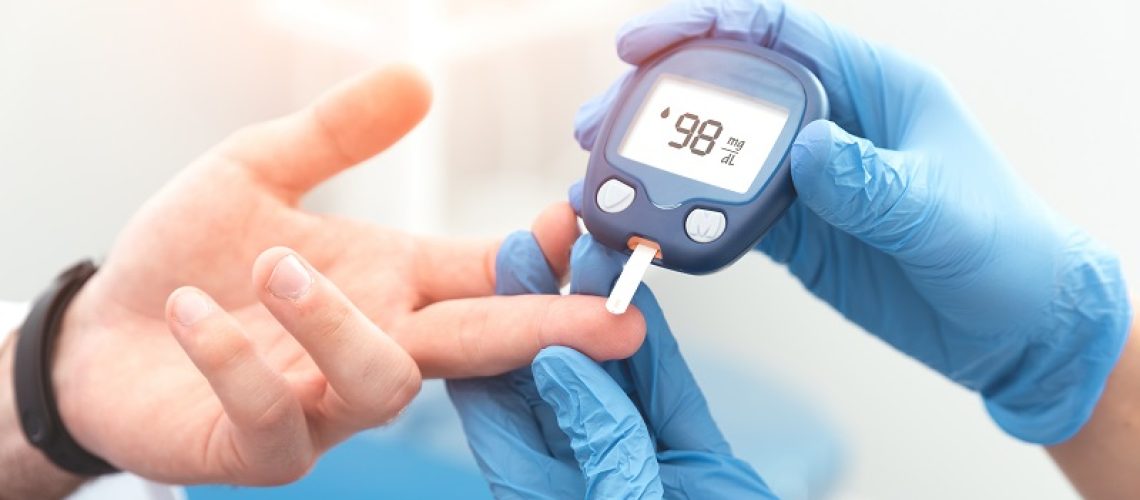 Doctor checking blood sugar level with glucometer. Treatment of diabetes concept.